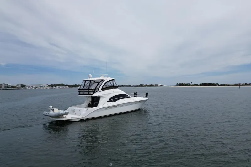 Slide: The Image of 2007 Sea Ray 52 Sedan Bridge yacht cruising on calm waters under a cloudy sky. - 9