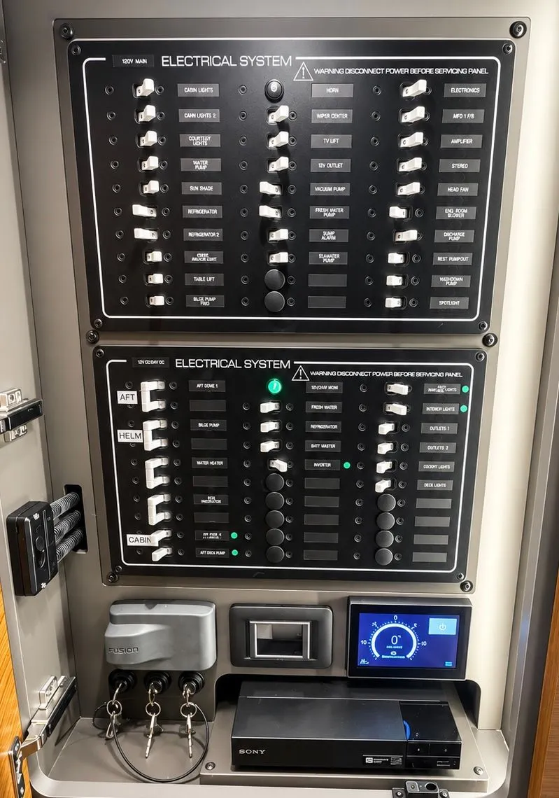 Slide: The Image of Tiara Yachts 48 LS 2023 electrical system panel with switches and indicators. - 28