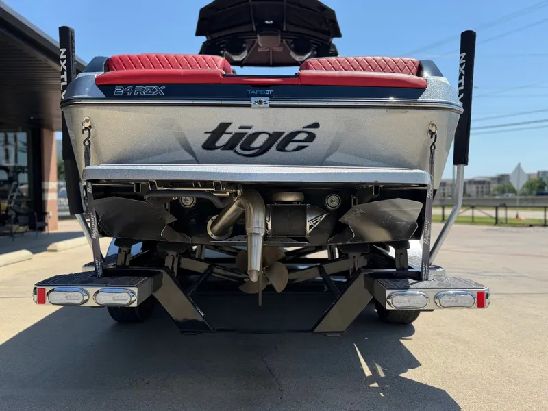 Slide: The Image of Rear view of a 2023 Tigé 24RZX boat on a trailer. - 19