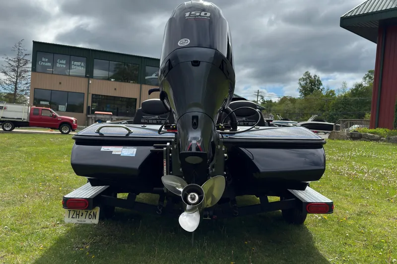 Slide: The Image of 2022 Skeeter ZX150 boat on trailer, rear view with outboard motor, parked on grass. - 11
