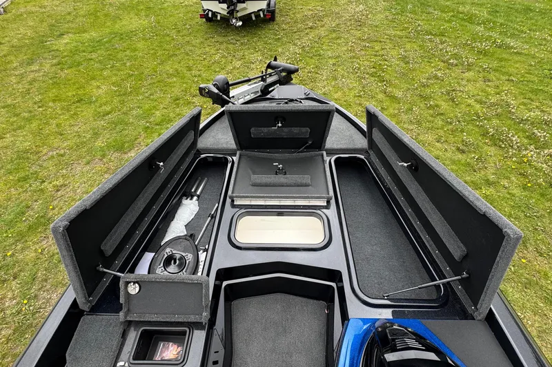 Slide: The Image of 2022 Skeeter ZX150 boat interior with open storage compartments on grassy background. - 15