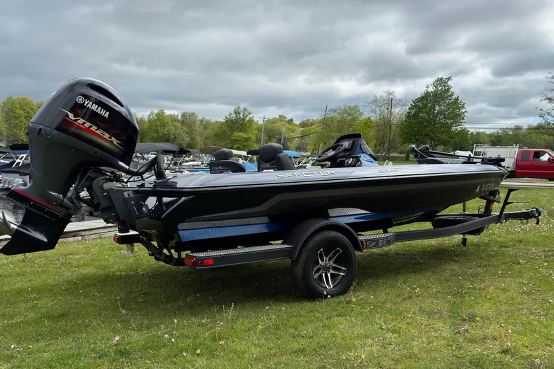 Slide: The Image of 2022 Skeeter ZX150 boat with Yamaha engine on grassy area under cloudy sky. - 2