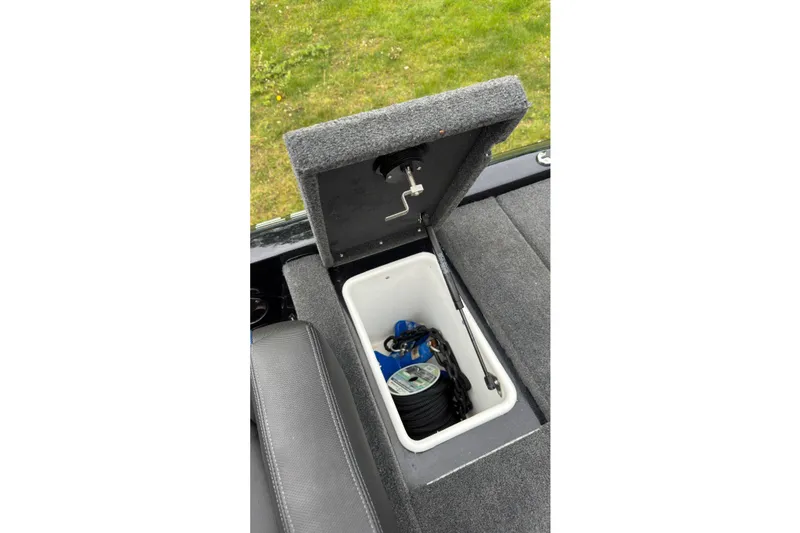 Slide: The Image of Open storage compartment in 2022 Skeeter ZX150 boat, revealing fishing gear inside. - 23