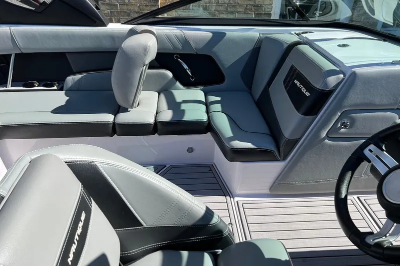 Slide: The Image of Interior of 2014 Nautique Super Air Nautique 210 boat, featuring sleek gray seating and modern design. - 10