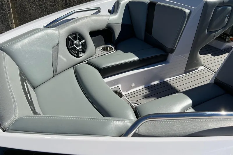 Slide: The Image of 2014 Nautique Super Air Nautique 210 boat interior with gray seating and speaker. - 14