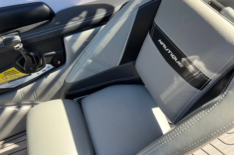 Slide: The Image of 2014 Nautique Super Air Nautique 210 interior seat with logo and control panel. - 16