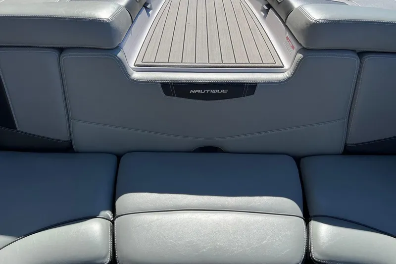 Slide: The Image of 2014 Nautique Super Air Nautique 210 boat interior with gray seating and deck. - 18