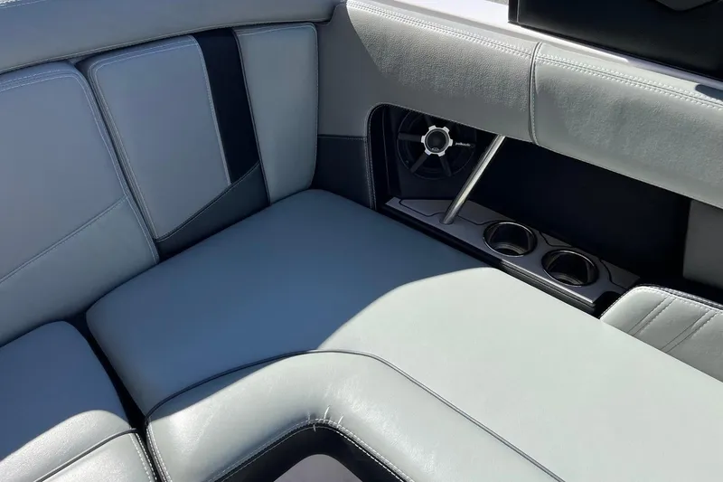 Slide: The Image of 2014 Nautique Super Air Nautique 210 interior with gray seating, speaker, and cup holders. - 19
