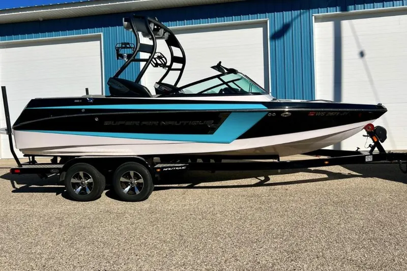 Slide: The Image of 2014 Nautique Super Air Nautique 210 boat on trailer, blue and black design. - 2