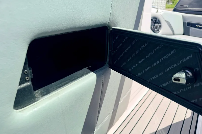 Slide: The Image of 2014 Nautique Super Air Nautique 210 storage compartment with open door and lock. - 64
