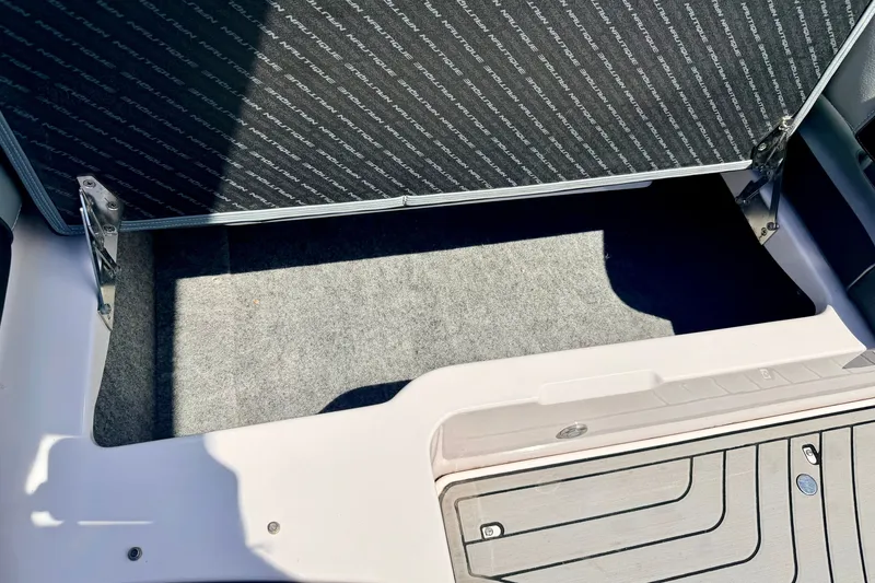 Slide: The Image of 2014 Nautique Super Air Nautique 210 storage compartment with carpeted interior and open hatch. - 42