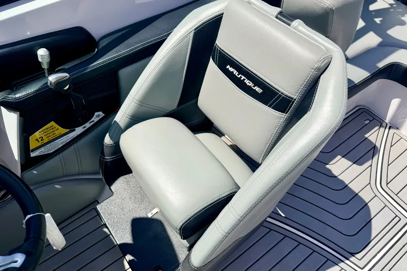 Slide: The Image of 2014 Nautique Super Air Nautique 210 boat interior with gray seating and control panel. - 59