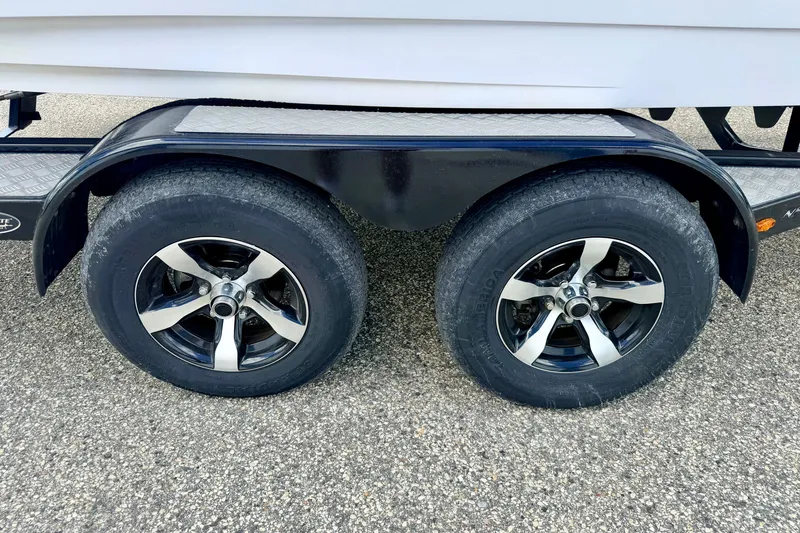 Slide: The Image of Trailer wheels of 2014 Nautique Super Air Nautique 210 on asphalt surface. - 107