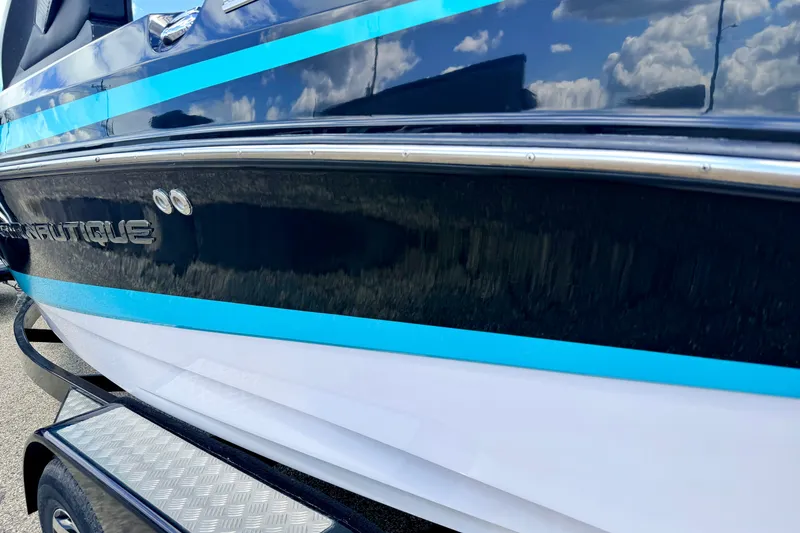 Slide: The Image of 2014 Nautique Super Air Nautique 210 boat with blue and white detailing. - 14