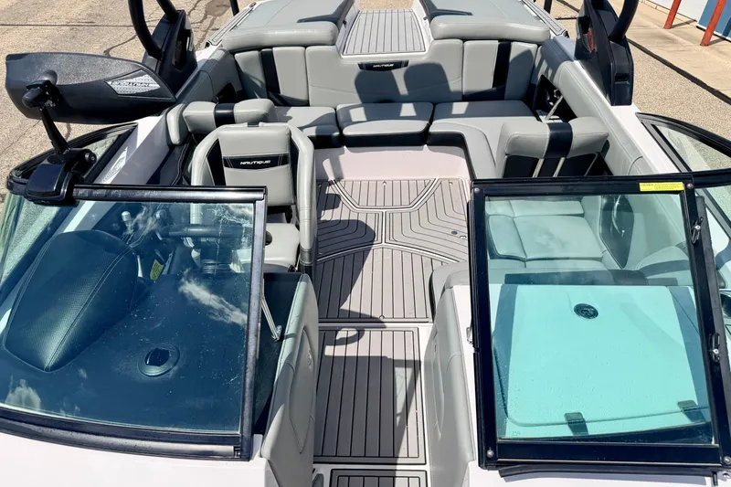 Slide: The Image of 2014 Nautique Super Air Nautique 210 interior with gray seating and open windshield. - 81