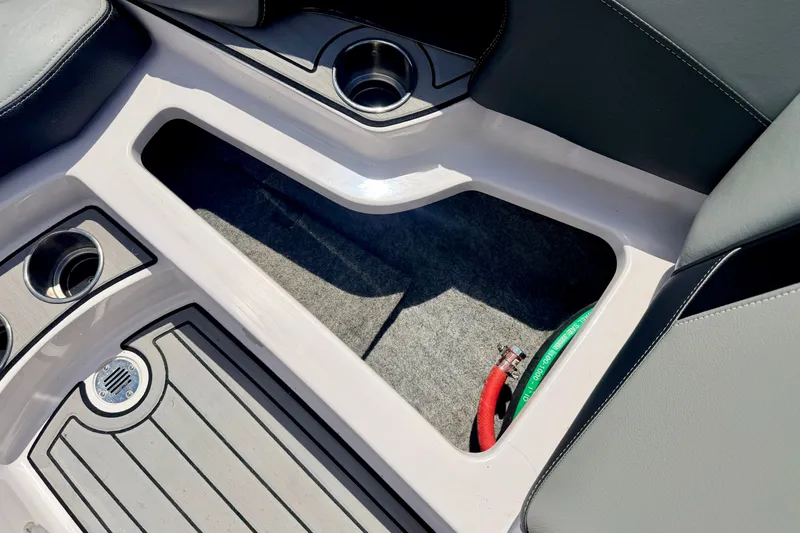 Slide: The Image of Interior of 2014 Nautique Super Air Nautique 210 boat with cup holders and storage space. - 73