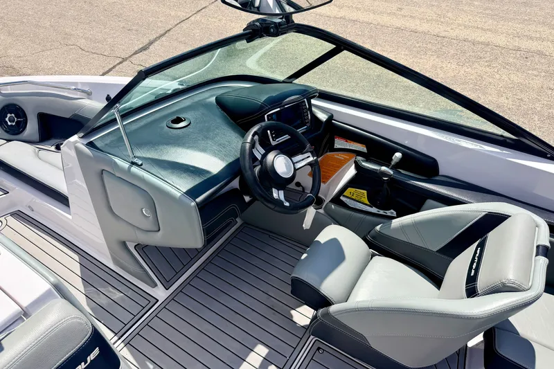 Slide: The Image of 2014 Nautique Super Air Nautique 210 boat interior with sleek dashboard and comfortable seating. - 85