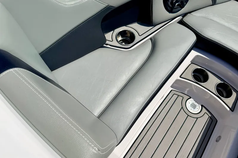 Slide: The Image of 2014 Nautique Super Air Nautique 210 interior with gray seating and cup holders. - 68