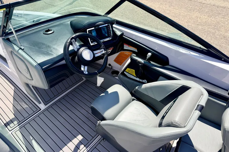 Slide: The Image of Interior of 2014 Nautique Super Air Nautique 210 boat, featuring sleek dashboard and seating. - 50