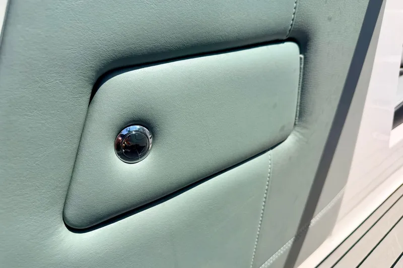 Slide: The Image of Interior detail of 2014 Nautique Super Air Nautique 210 boat, featuring sleek upholstery and chrome accent. - 63