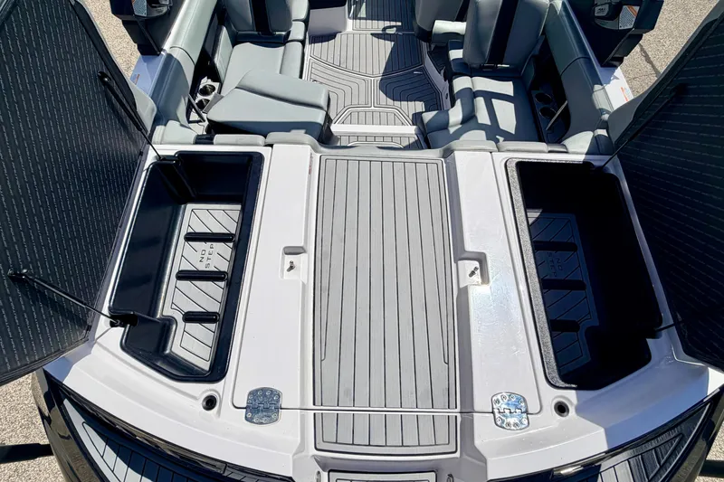 Slide: The Image of 2014 Nautique Super Air Nautique 210 boat interior with open storage compartments. - 29