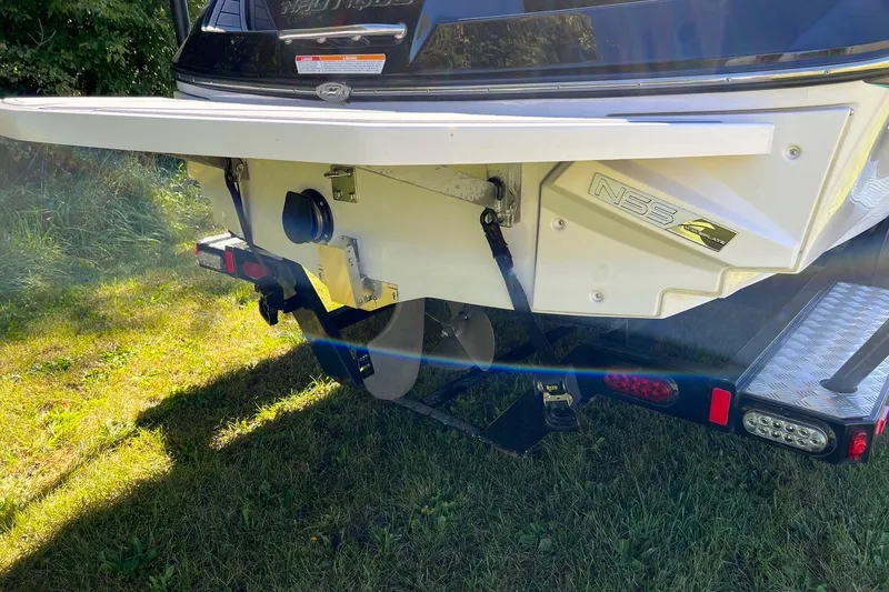 Slide: The Image of 2014 Nautique Super Air Nautique 210 boat rear view on grass. - 7