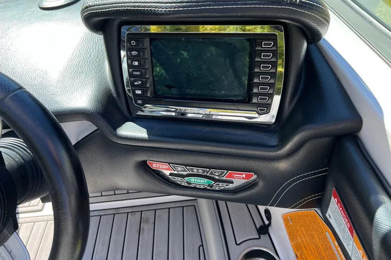 Slide: The Image of 2014 Nautique Super Air Nautique 210 dashboard with control panel and display screen. - 8