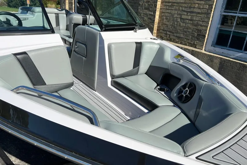 Slide: The Image of 2014 Nautique Super Air Nautique 210 boat interior with gray seating and speaker. - 9