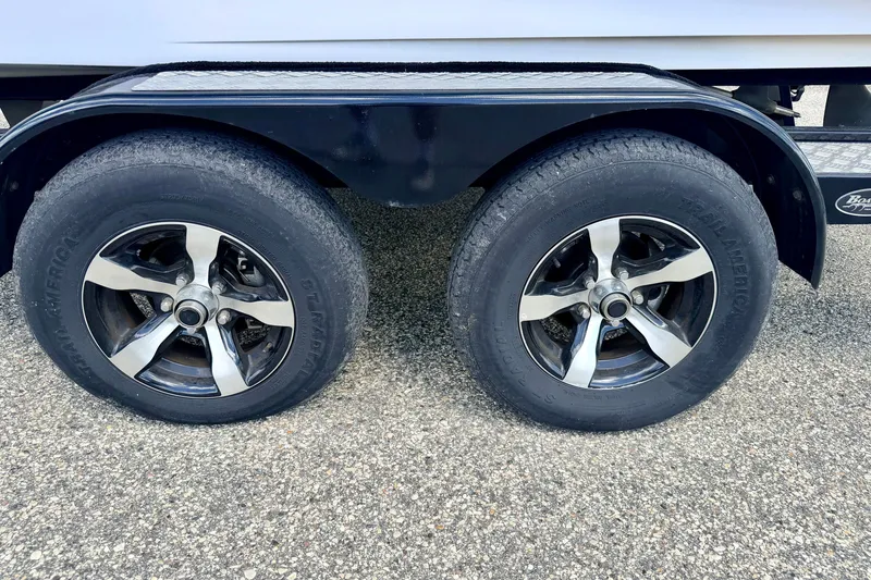 Slide: The Image of Trailer wheels of a 2014 Nautique Super Air Nautique 210 on a textured surface. - 104