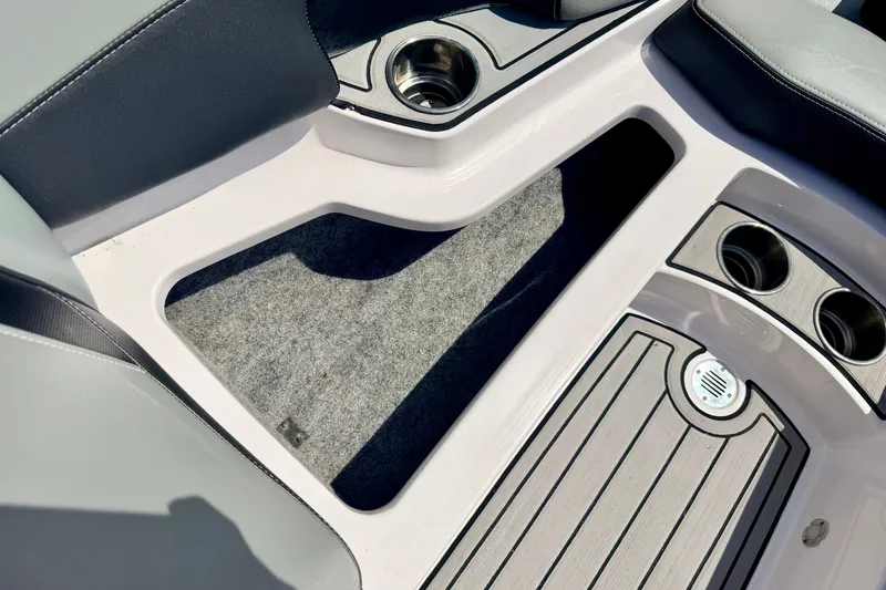 Slide: The Image of Interior of 2014 Nautique Super Air Nautique 210 boat with cup holders and carpeted flooring. - 69