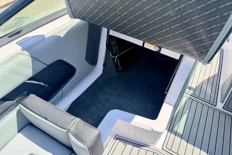 Slide: The Image of 2014 Nautique Super Air Nautique 210 interior storage compartment with seating and flooring. - 48