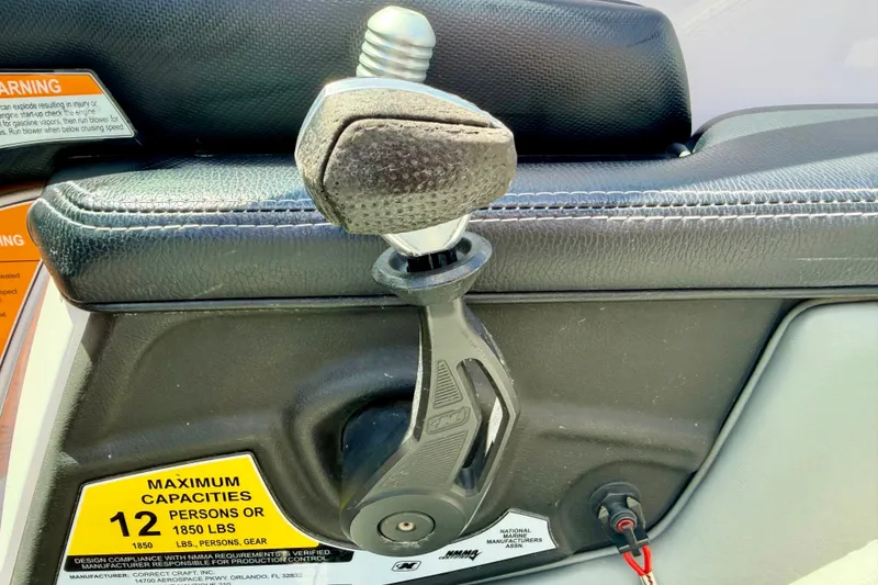 Slide: The Image of Throttle control of 2014 Nautique Super Air Nautique 210 boat, showing capacity warning label. - 56
