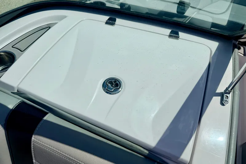 Slide: The Image of 2014 Nautique Super Air Nautique 210 boat interior detail with storage compartment and cup holder. - 60