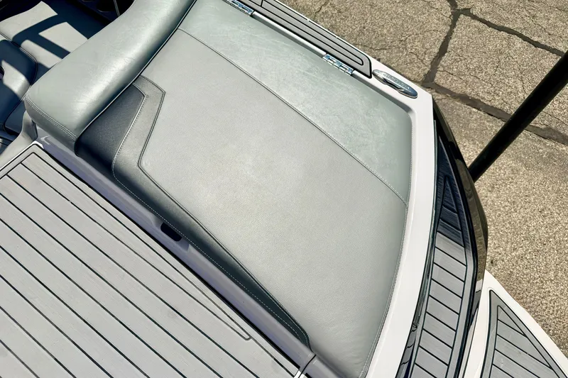 Slide: The Image of 2014 Nautique Super Air Nautique 210 boat interior with gray seating and deck. - 23
