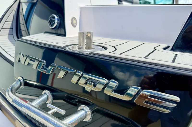 Slide: The Image of 2014 Nautique Super Air Nautique 210 boat detail with logo and deck view. - 98