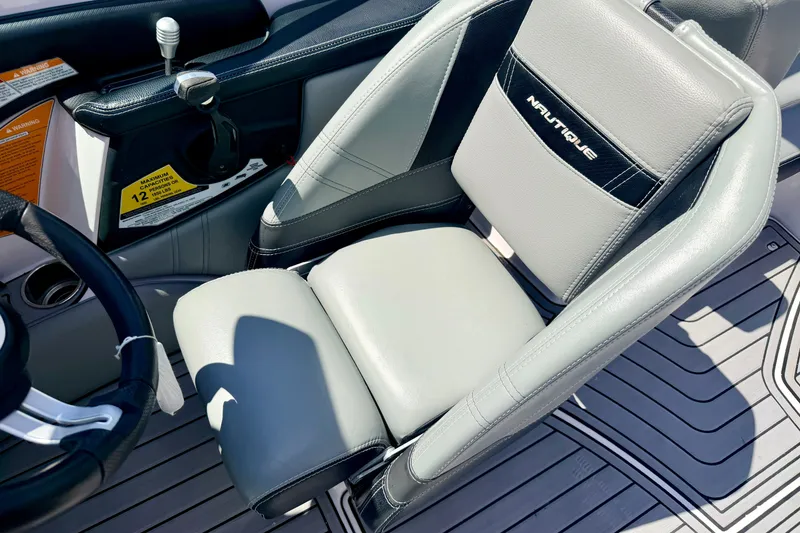 Slide: The Image of 2014 Nautique Super Air Nautique 210 driver's seat and controls, featuring sleek design and premium materials. - 58