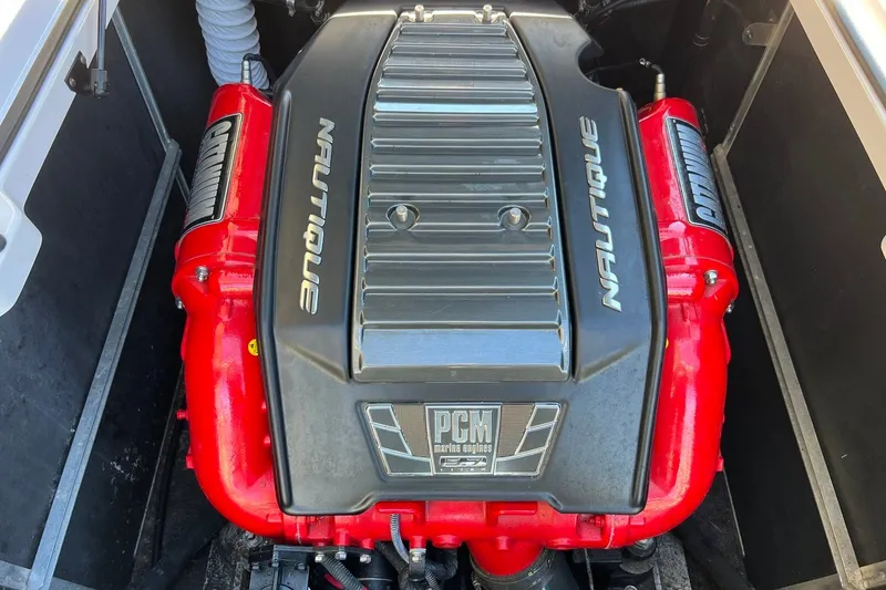 Slide: The Image of 2014 Nautique Super Air Nautique 210 engine with PCM branding, featuring red components. - 15