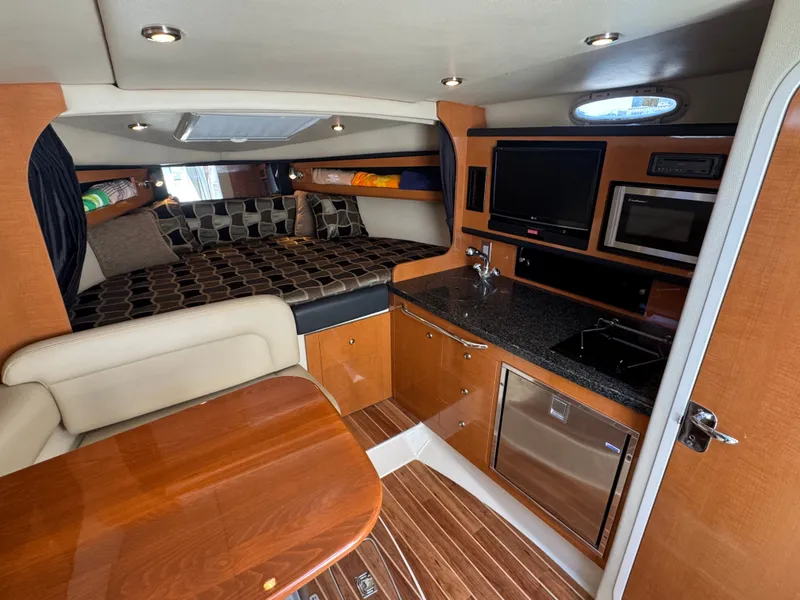 Slide: The Image of Interior of 2011 Chaparral 290 Signature with kitchen and sleeping area. - 14