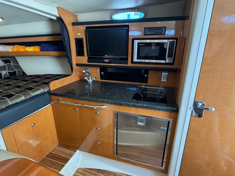 Slide: The Image of Interior of 2011 Chaparral 290 Signature with kitchen and sleeping area. - 16