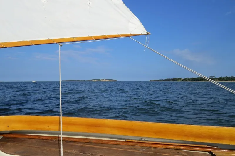 Slide: The Image of Sailing on a 1997 COMPASS CLASSIC Catboat with ocean and island views. - 11