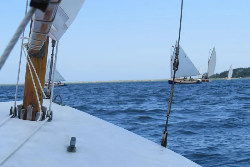 Slide: The Image of Sailing on a 1997 COMPASS CLASSIC Catboat, with other sailboats in the distance. - 13