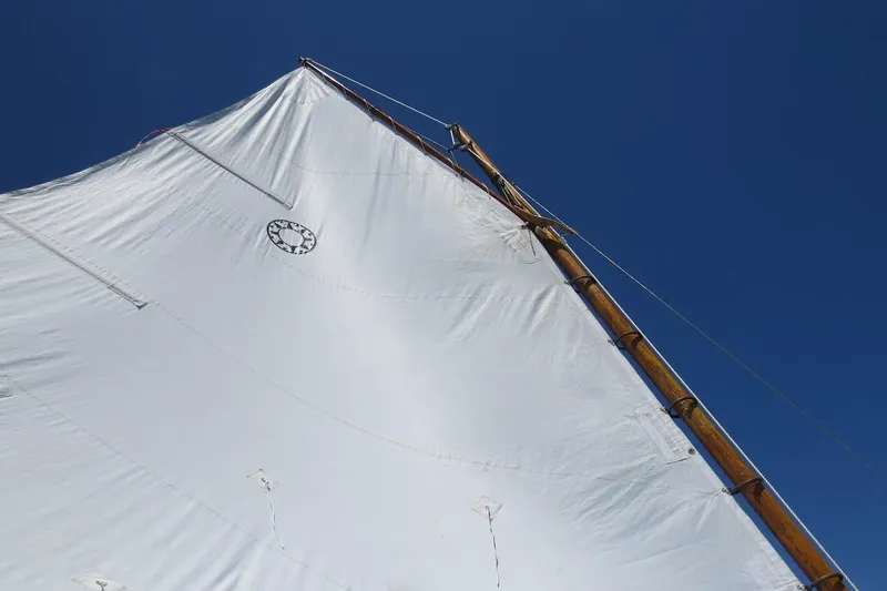 Slide: The Image of Sail of a 1997 COMPASS CLASSIC Catboat against a clear blue sky. - 9