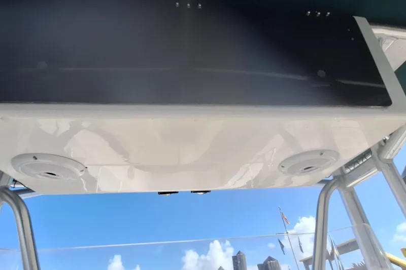 Slide: The Image of T-top view of 2001 Dusky 252 Open Fisherman boat against blue sky. - 13