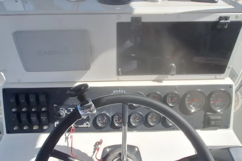 Slide: The Image of Dashboard of 2001 Dusky 252 Open Fisherman boat with steering wheel and gauges. - 14