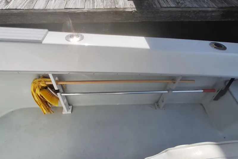 Slide: The Image of Interior of a 2001 Dusky 252 Open Fisherman boat with cleaning tools stored. - 16