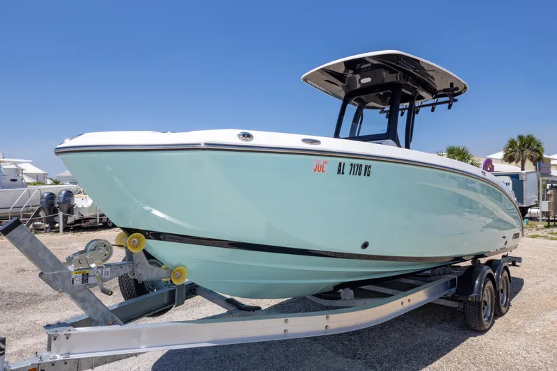 Slide: The Image of 2025 Yamaha Boats 255 FSH Sport E on trailer, sleek design, sunny day. - 17