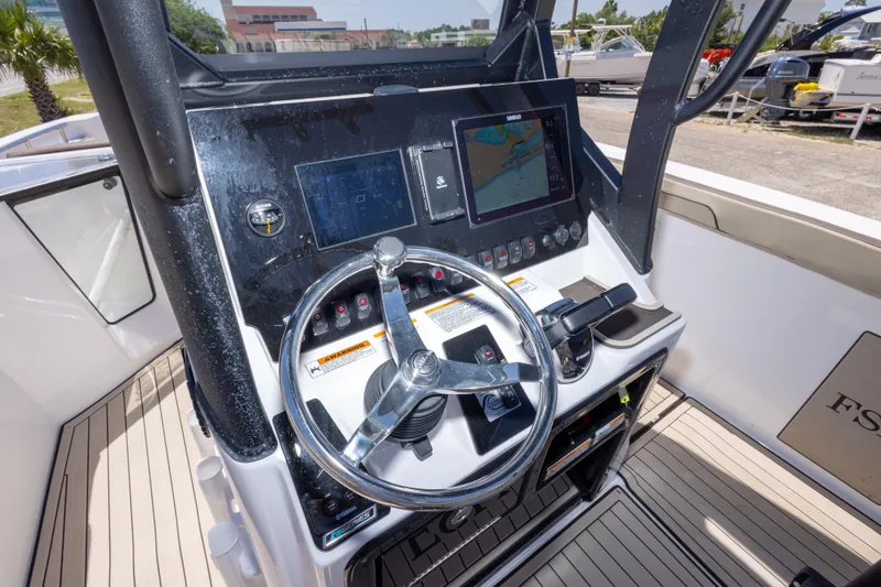 Slide: The Image of 2025 Yamaha Boats 255 FSH Sport E dashboard with steering wheel and navigation screens. - 24