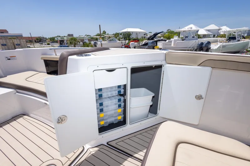 Slide: The Image of 2025 Yamaha Boats 255 FSH Sport E storage compartment with open doors, showcasing organized interior. - 39