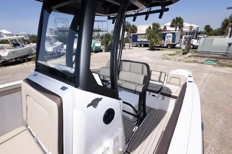 Slide: The Image of 2025 Yamaha Boats 255 FSH Sport E interior with seating and console, docked outdoors. - 40