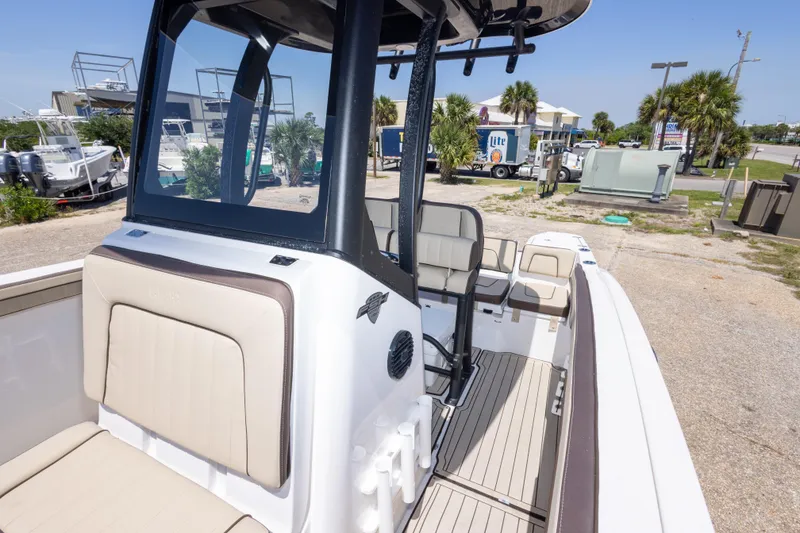 Slide: The Image of 2025 Yamaha Boats 255 FSH Sport E interior with seating and console, docked outdoors. - 42